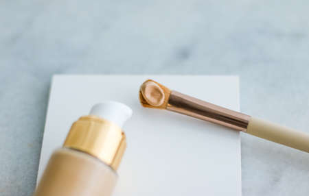 Cosmetic branding, glamour and skincare concept - Makeup foundation bottle and contouring brush on...