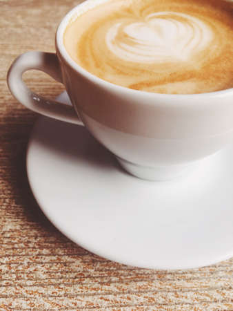Morning drink, breakfast and rustic style concept - Cup of hot cappuccino in a cafeteria, coffee on a wooden table in cafeの写真素材
