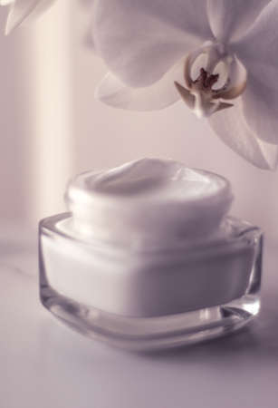 Cosmetic branding, toiletries and spf concept - Face cream moisturizer jar and orchid flower, moisturizing skin care lotion and lifting emulsion, anti-age cosmetics for luxury beauty skincare brandの写真素材