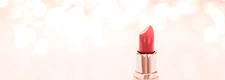Cosmetic branding, sale and glamour concept - Coral lipstick on rose gold Christmas, New Years and Valentines Day holiday glitter background, make-up and cosmetics product for luxury beauty brandの写真素材