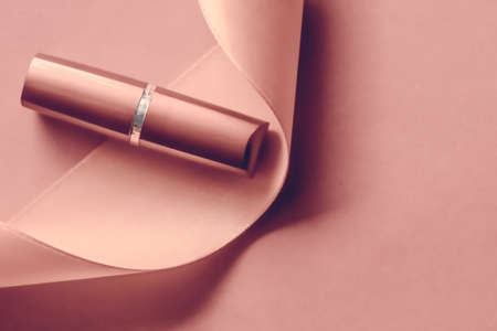 Cosmetic branding, glamour lip gloss and shopping sale concept - Luxury lipstick and silk ribbon on blush pink holiday background, make-up and cosmetics flatlay for beauty brand product designの写真素材
