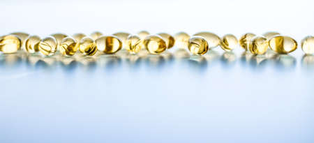 Pharmaceutical, branding and science concept -  Vitamin D and golden Omega 3 pills for healthy diet nutrition, fish oil food supplement pill capsules, healthcare and medicine as pharmacy backgroundの写真素材