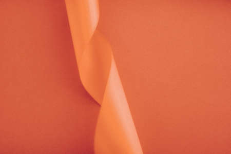 Branding, holidays and luxe brands concept - Abstract curly silk ribbon on orange background, exclusive luxury brand design for holiday sale product promotion and glamour art invitation card backdropの写真素材