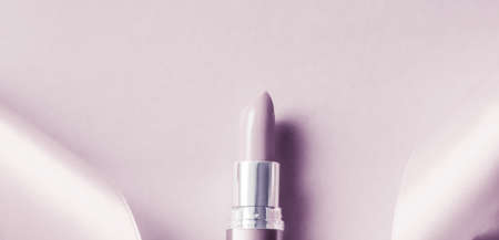 Cosmetic branding, glamour lip gloss and shopping sale concept - Luxury lipstick and silk ribbon on blush purple holiday background, make-up and cosmetics flatlay for beauty brand product designの写真素材