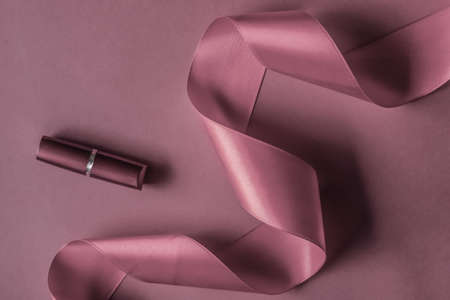Cosmetic branding, glamour lip gloss and shopping sale concept - Luxury lipstick and silk ribbon on purple holiday background, make-up and cosmetics flatlay for beauty brand product designの写真素材