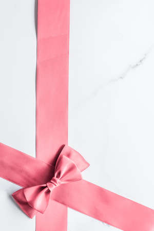 Birthday, wedding and girly branding concept - Coral silk ribbon and bow on marble background, girl baby shower present and glamour fashion gift decor for luxury beauty brand, holiday flatlay designの写真素材