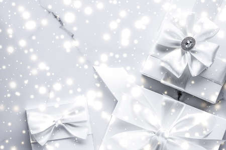 New Years Eve celebration, winter decoration and Valentines Day presents concept - Luxury holiday gifts with white silk bow and ribbons on marble background, Christmas time surpriseの写真素材