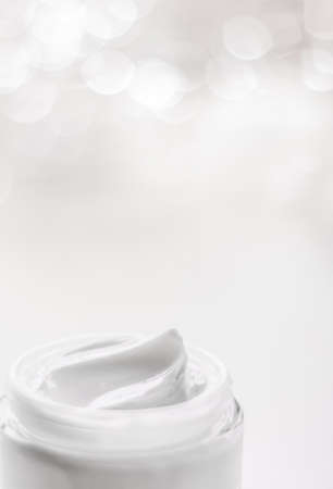 Cosmetic branding, gift and spa concept - Facial cream moisturizer jar on holiday glitter background, moisturizing skin care as lifting emulsion, anti-age cosmetics for luxury beauty skincare brandの写真素材