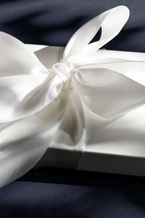 Anniversary celebration, shop sale promotion and luxe surprise concept - Luxury holiday white gift box with silk ribbon and bow on black background, luxe wedding or birthday presentの写真素材