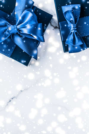 Branding, glamour and cold season concept - Winter holiday gift box with blue silk bow, snow glitter on marble background as Christmas and New Years presents for luxury beauty brand, flatlay designの写真素材