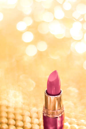 Cosmetic branding, sale and glamour concept - Rose lipstick on golden Christmas, New Years and Valentines Day holiday glitter background, make-up and cosmetics product for luxury beauty brandの写真素材