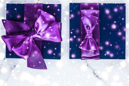 Branding, glamour and cold season concept - Winter holiday gift box with purple silk bow, snow...