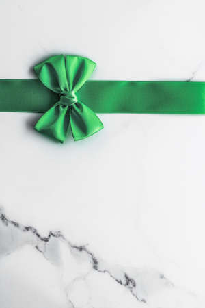 Decorative, birthday and art branding concept - Green silk ribbon and bow on marble background, St Patricks day present or Christmas glamour gift decor for luxury digital brand, holiday flatlay designの写真素材