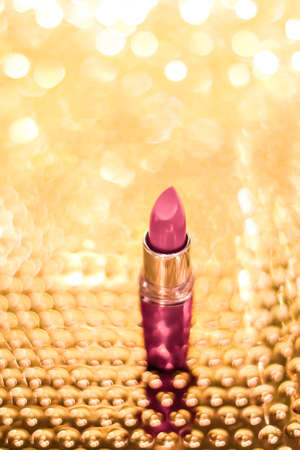 Cosmetic branding, sale and glamour concept - Rose lipstick on golden Christmas, New Years and Valentines Day holiday glitter background, make-up and cosmetics product for luxury beauty brandの写真素材