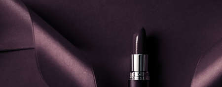 Cosmetic branding, glamour lip gloss and shopping sale concept - Luxury lipstick and silk ribbon on dark purple holiday background, make-up and cosmetics flatlay for beauty brand product designの写真素材