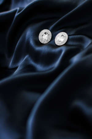 Jewellery brand, elegant fashion and bridal luxe gift concept - Luxury diamond earrings on dark blue...