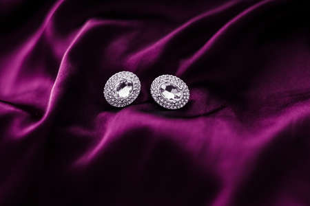 Jewellery brand, elegant fashion and bridal luxe gift concept - Luxury diamond earrings on dark pink silk fabric, holiday glamour jewelery presentの写真素材