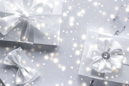 New Years Eve celebration, winter decoration and Valentines Day presents concept - Luxury holiday gifts with white silk bow and ribbons on marble background, Christmas time surpriseの写真素材