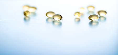 Pharmaceutical, branding and science concept -  Vitamin D and golden Omega 3 pills for healthy diet nutrition, fish oil food supplement pill capsules, healthcare and medicine as pharmacy backgroundの写真素材