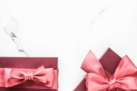 Birthday, wedding and girly branding concept - Coral gift box with silk bow on marble background, girl baby shower present and glamour fashion gift for luxury beauty brand, holiday flatlay art designの写真素材
