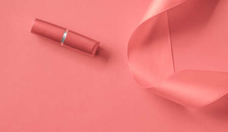 Cosmetic branding, glamour lip gloss and shopping sale concept - Luxury lipstick and silk ribbon on coral holiday background, make-up and cosmetics flatlay for beauty brand product designの写真素材