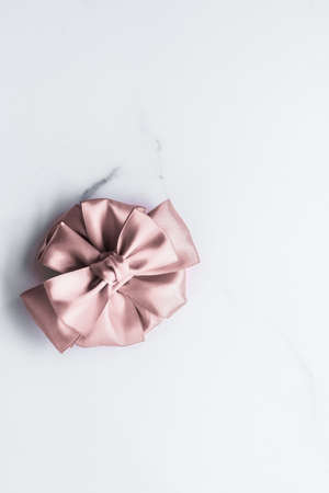 Birthday, wedding and girly branding concept - Beige silk ribbon and bow on marble background, glamour present mockup and fashion gift decoration for luxury beauty brand holiday flatlay designの写真素材