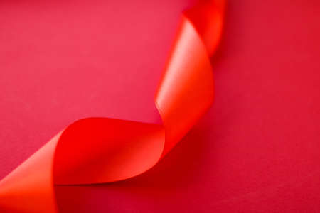 Branding, holidays and luxe brands concept - Abstract curly silk ribbon on red background, exclusive luxury brand design for holiday sale product promotion and glamour art invitation card backdropの写真素材
