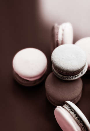 Pastry, bakery and branding concept - French macaroons on milk chocolate background, parisian chic...