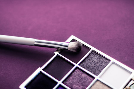 Cosmetic branding, mua and girly concept - Eyeshadow palette and make-up brush on purple background, eye shadows cosmetics product as luxury beauty brand promotion and holiday fashion blog designの写真素材