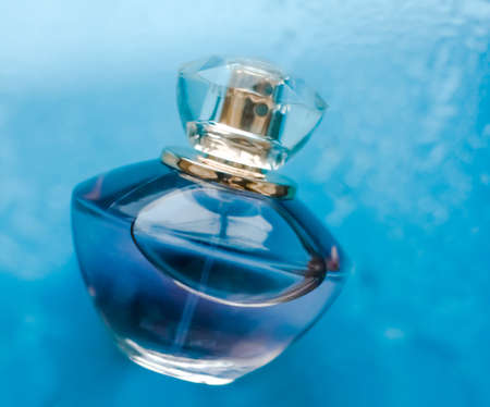 Perfumery, cosmetics and branding concept - Perfume bottle under blue water, fresh sea coastal scent...