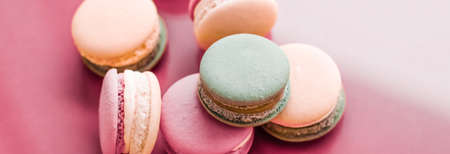 Pastry, bakery and branding concept - French macaroons on pastel pink background, parisian chic cafe...