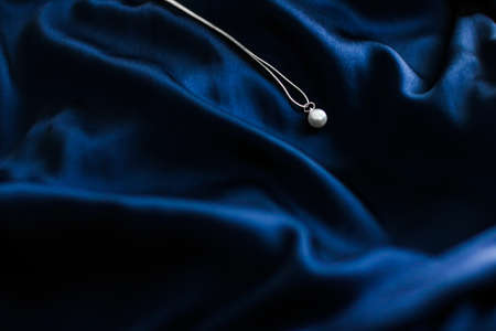 Jewellery brand, elegant fashion and bridal luxe gift concept - Luxury white gold pearl necklace on dark blue silk background, holiday glamour jewelery presentの写真素材