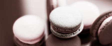 Pastry, bakery and branding concept - French macaroons on milk chocolate background, parisian chic cafe dessert, sweet food and cake macaron for luxury confectionery brand, holiday backdrop designの写真素材
