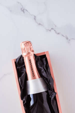 Celebration, drink and branding concept - Champagne bottle and gift box on marble, New Years,...
