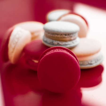 Pastry, bakery and branding concept - French macaroons on wine red background, parisian chic cafe dessert, sweet food and cake macaron for luxury confectionery brand, holiday backdrop designの写真素材