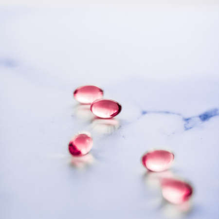 Pharmaceutical, branding and science concept - Red pills for healthy diet nutrition, supplements pill and probiotics capsules, healthcare and medicine as pharmacy and scientific research backgroundの写真素材