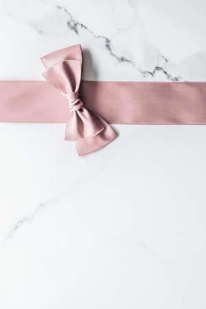 Birthday, wedding and girly branding concept - Beige silk ribbon and bow on marble background, glamour present mockup and fashion gift decoration for luxury beauty brand holiday flatlay designの写真素材