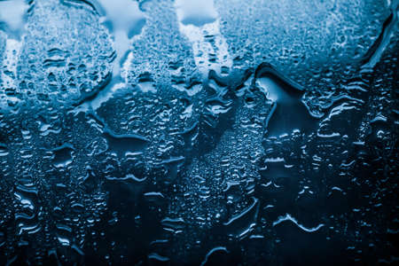 Liquid, wet and zen concept - Water texture abstract background, aqua drops on blue glass as science macro element, rainy weather and nature surface art backdrop for environmental brand designの写真素材