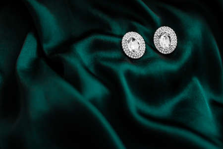 Jewellery brand, elegant fashion and bridal luxe gift concept - Luxury diamond earrings on dark emerald green silk, holiday glamour jewelery presentの写真素材