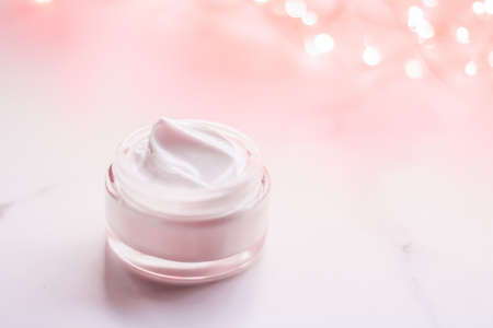 Cosmetic branding, gift and spa concept - Facial cream moisturizer jar on holiday glitter background, moisturizing skin care as lifting emulsion, anti-age cosmetics for luxury beauty skincare brandの写真素材