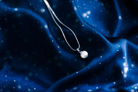 Jewellery brand, Christmas shopping and Valentines day gift concept - Luxury white gold pearl necklace on dark blue silk, holiday winter magic jewelery presentの写真素材