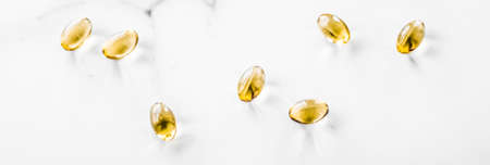 Pharmaceutical, branding and science concept -  Vitamin D and golden Omega 3 pills for healthy diet nutrition, fish oil food supplement pill capsules, healthcare and medicine as pharmacy backgroundの写真素材