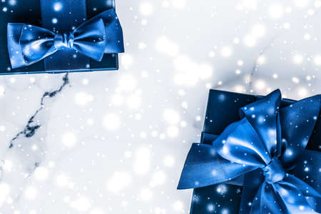 Branding, glamour and cold season concept - Winter holiday gift box with blue silk bow, snow glitter...