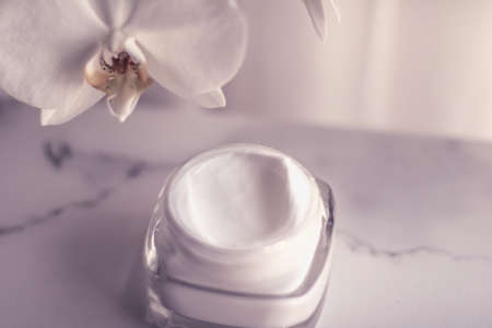 Cosmetic branding, toiletries and spf concept - Face cream moisturizer jar and orchid flower, moisturizing skin care lotion and lifting emulsion, anti-age cosmetics for luxury beauty skincare brandの写真素材