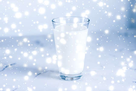 Dairy products, healthy diet and Christmas food concept - Magic holiday drink, pouring organic lactose free milk into glass on marble tableの写真素材