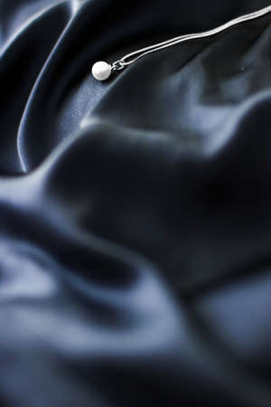 Jewellery brand, elegant fashion and bridal luxe gift concept - Luxury white gold pearl necklace on dark blue silk background, holiday glamour jewelery presentの写真素材