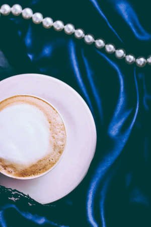 Menu, branding and recipe concept - Cup of cappuccino for breakfast with satin and pearls jewellery background, organic coffee with lactose free milk in parisian cafe for luxury vintage holiday brandの写真素材