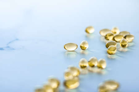 Pharmaceutical, branding and science concept -  Vitamin D and golden Omega 3 pills for healthy diet nutrition, fish oil food supplement pill capsules, healthcare and medicine as pharmacy backgroundの写真素材