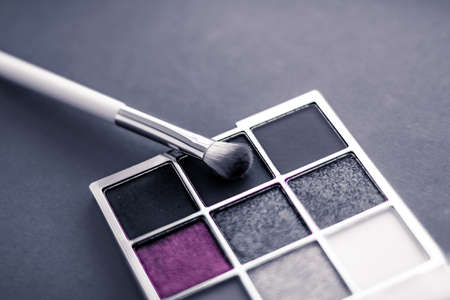 Cosmetic branding, mua and girly concept - Eyeshadow palette and make-up brush on graphite background, eye shadows cosmetics product for luxury beauty brand promotion and holiday fashion blog designの写真素材
