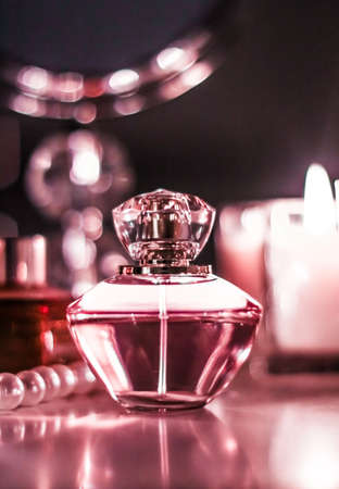 Perfumery, cosmetics branding and luxe concept - Perfume bottle and vintage fragrance on glamour vanity table at night, pearls jewellery and eau de parfum as holiday gift, luxury beauty brand presentの写真素材